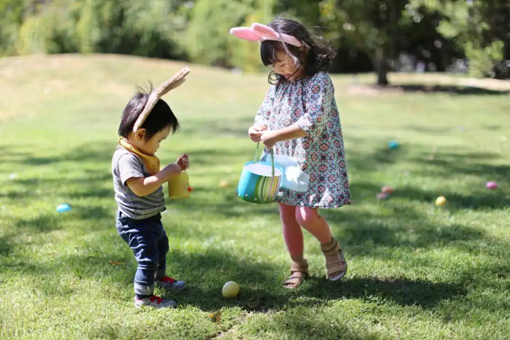 Two children playing in a field whilst on an Easter Egg hunt in Cornwall.