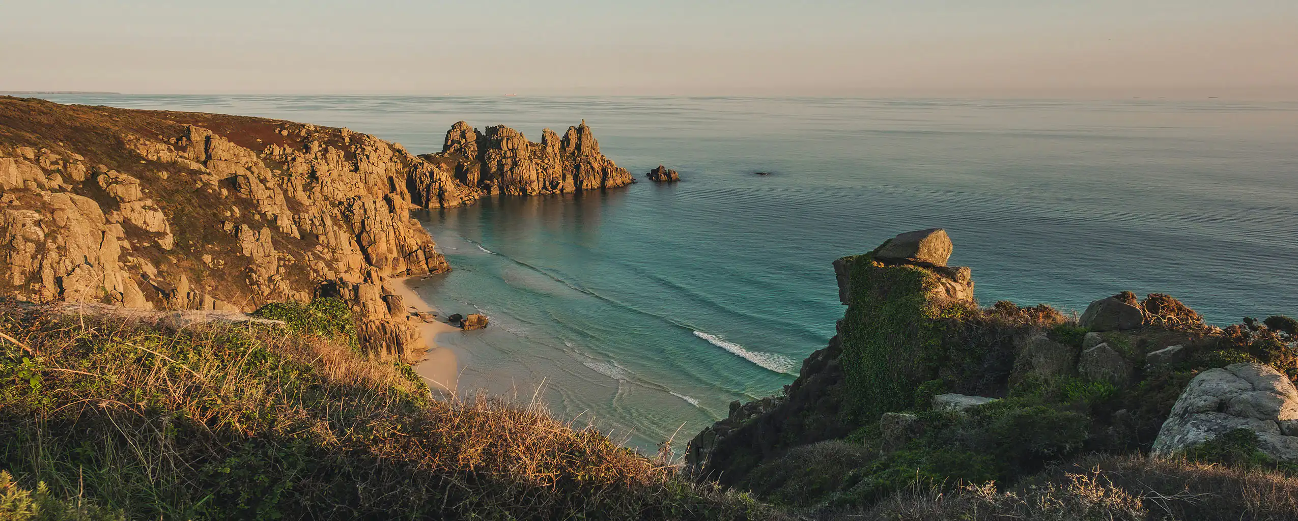Scenic view of the ocean and Cornwall Cliffs from a hill, showcasing rugged cliffs meeting the blue sea, a great excursion from a holiday cottages on our latest offers.