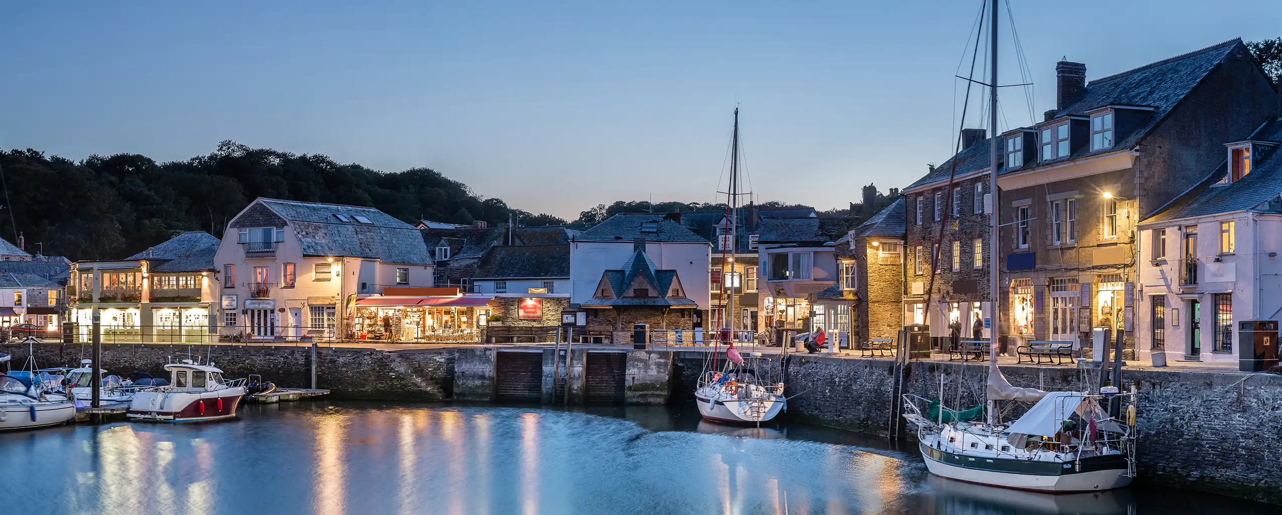 Boats are docked in Padstow Harbour at dusk, a great place for dinner from your Padstow holiday Cottage.