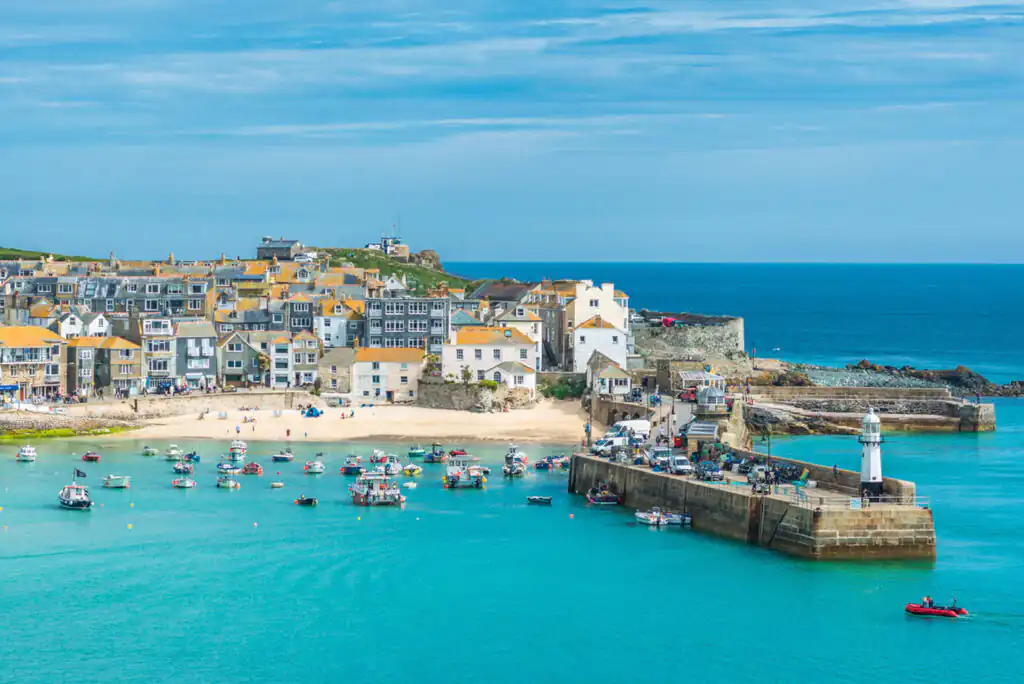 St Ives beach featuring a vibrant shoreline with boats floating in the calm water, perfect for a day of relaxation