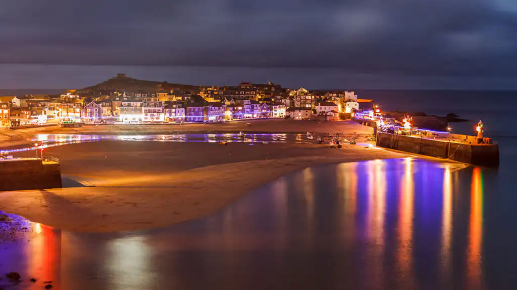 St Ives Harbour illuminated at night with festive Christmas lights, celebrating the New Year in Cornwall.