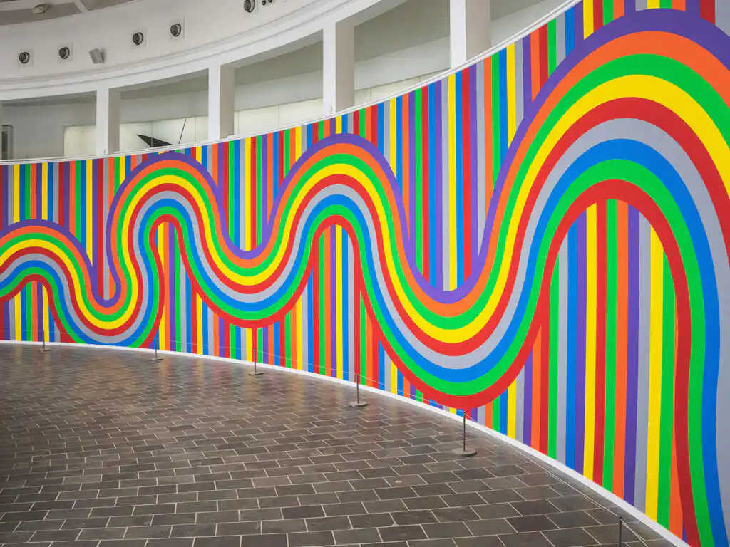 A vibrant wall featuring a variety of colorful stripes, showcasing the artistic atmosphere of Tate St Ives in Cornwall.