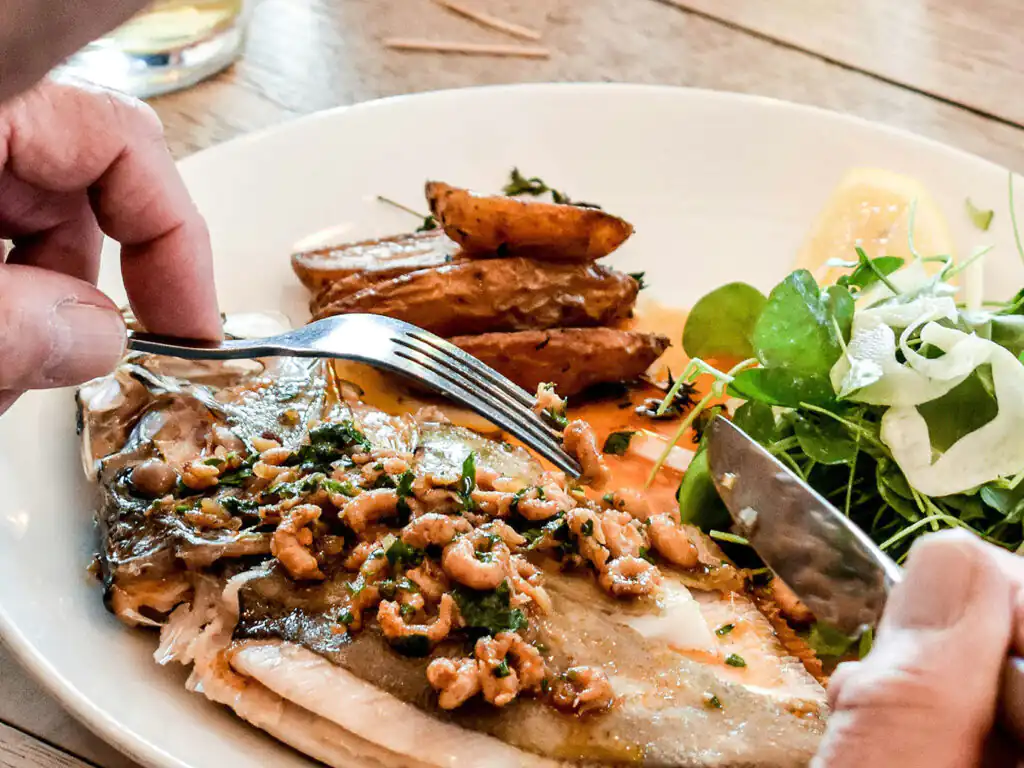A beautifully presented seafood dish on a table, showcasing the culinary delights of Cornwall, a perfect romantic trip.