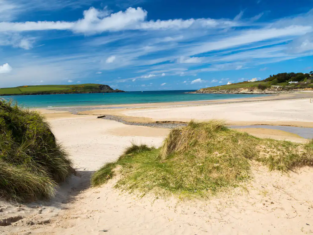 A sunny Daymer Bay beach with soft sand and gentle waves, perfect for relaxation and seaside activities in Padstow.