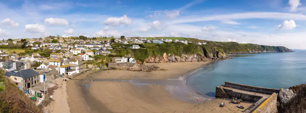 Scenic view of Gorran Haven beach with coastal houses, a notable film and television location in Cornwall.