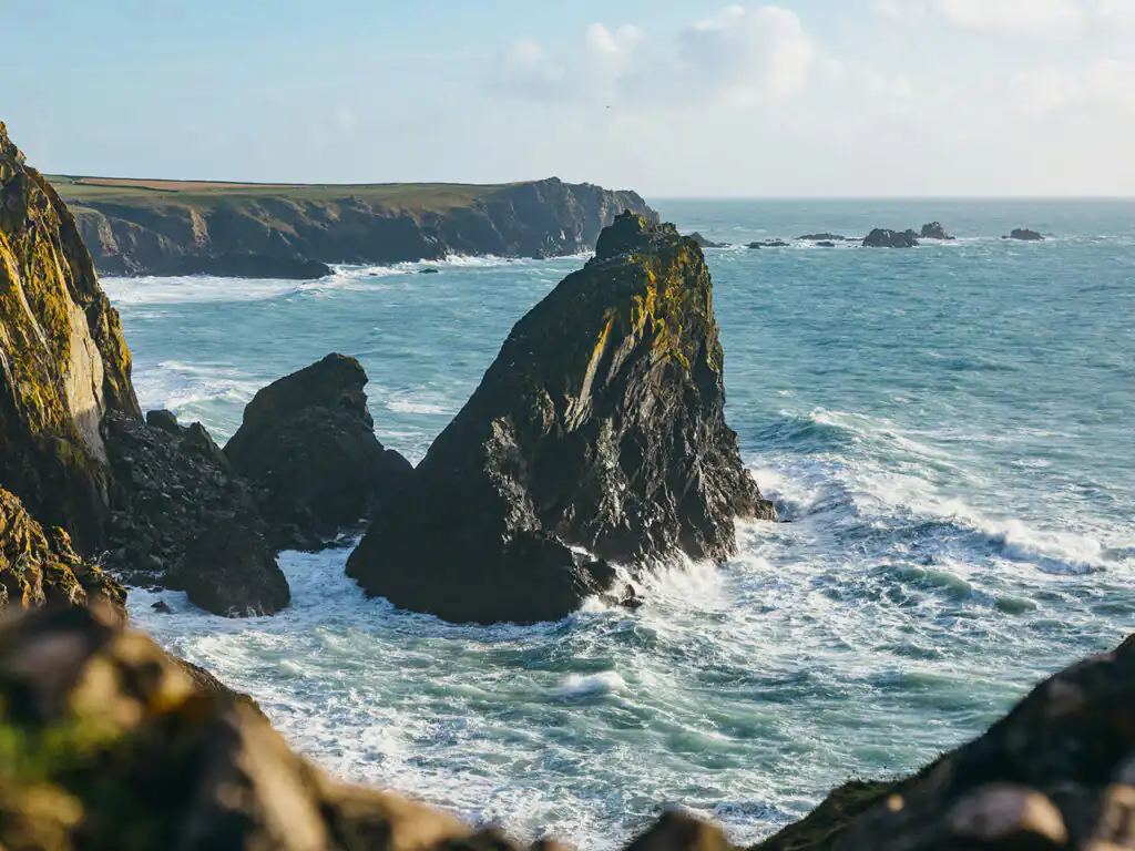 Scenic view of Kynance Cove, featuring the ocean waves crashing against rocky formations in Cornwall.