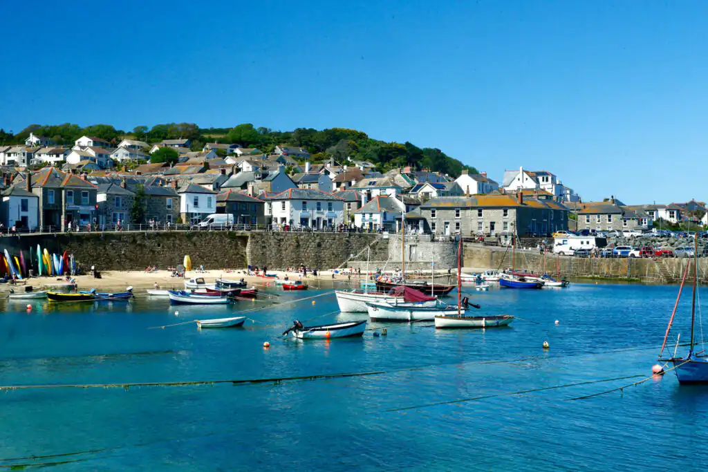A clear blue sky over Mousehole, a picturesque fishing village in Cornwall, inviting exploration and adventure.