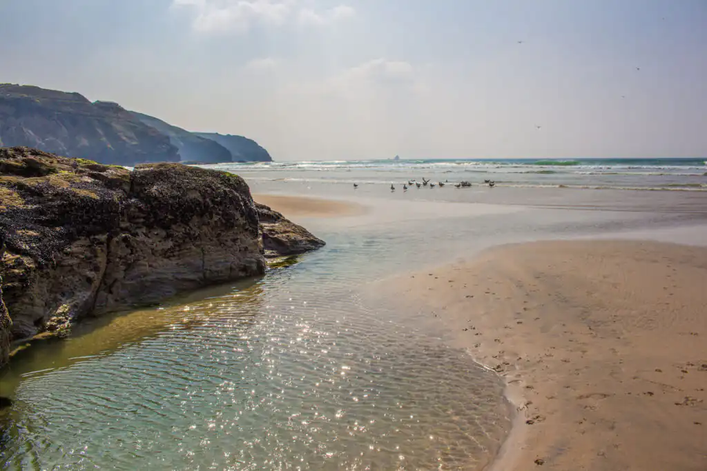 A scenic view of Perranporth Beach, showcasing the expansive body of water ideal for surfing in Cornwall.