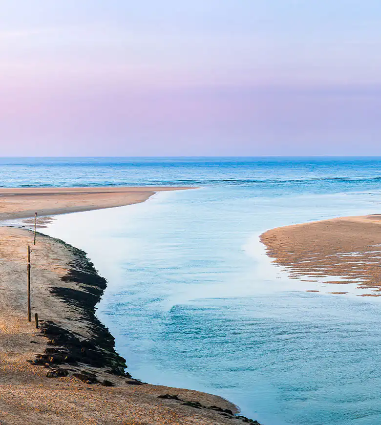 Scenic view of Porthkidney Beach in Lelant, featuring a river flowing to the sea.
