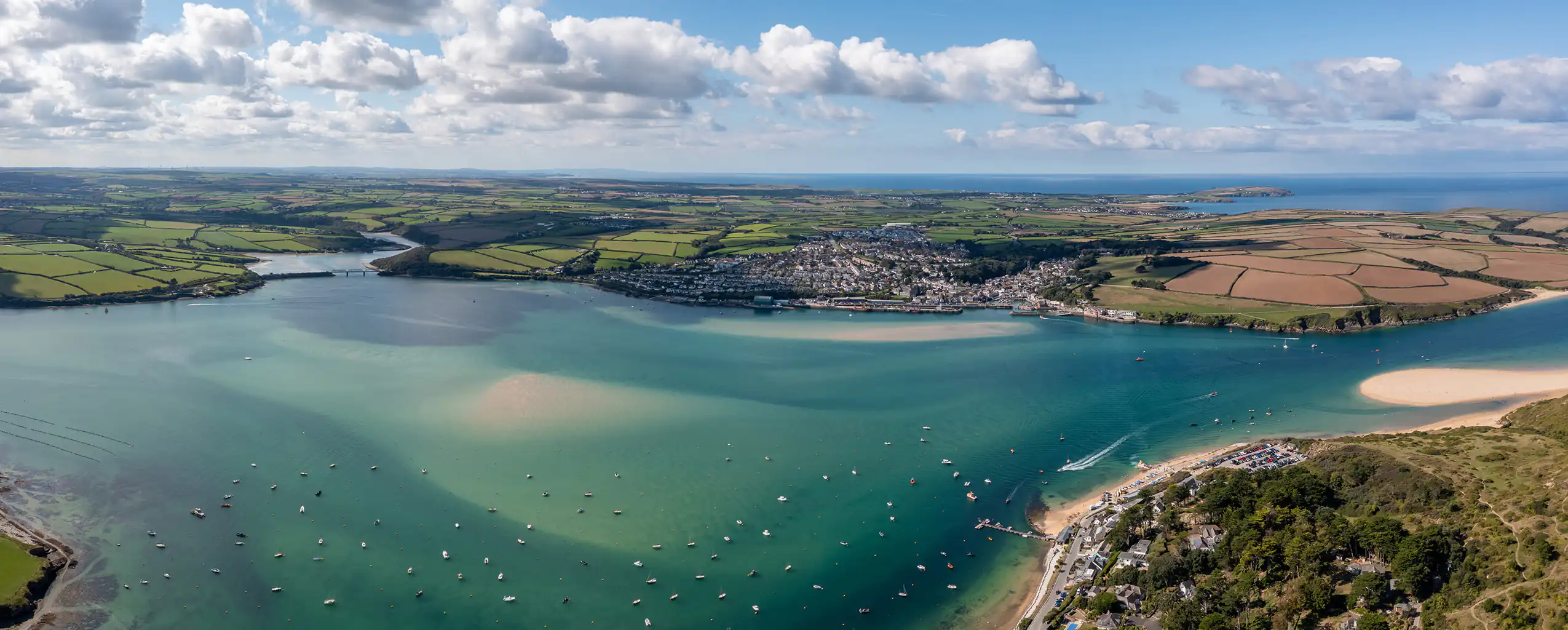 Bird's-eye view of Padstow along the Camel Estuary, capturing the stunning coastline and tranquil waters.