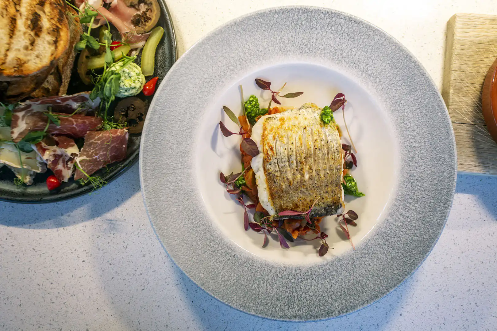 A plate featuring a grilled fish alongside a fresh salad, enjoyed at Med Terrace in The Eden Project.