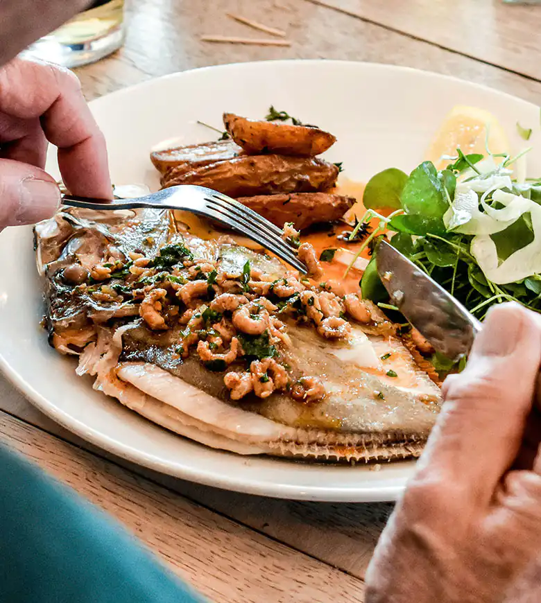 A beautifully presented seafood dish on a table, showcasing the culinary delights of Cornwall.