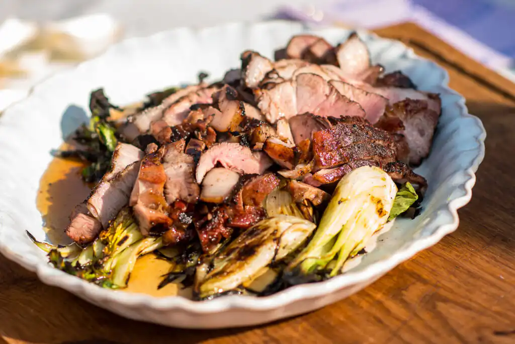A plate of colourful meat and vegetables served on a rustic wooden table at the St Ives Food Festival.