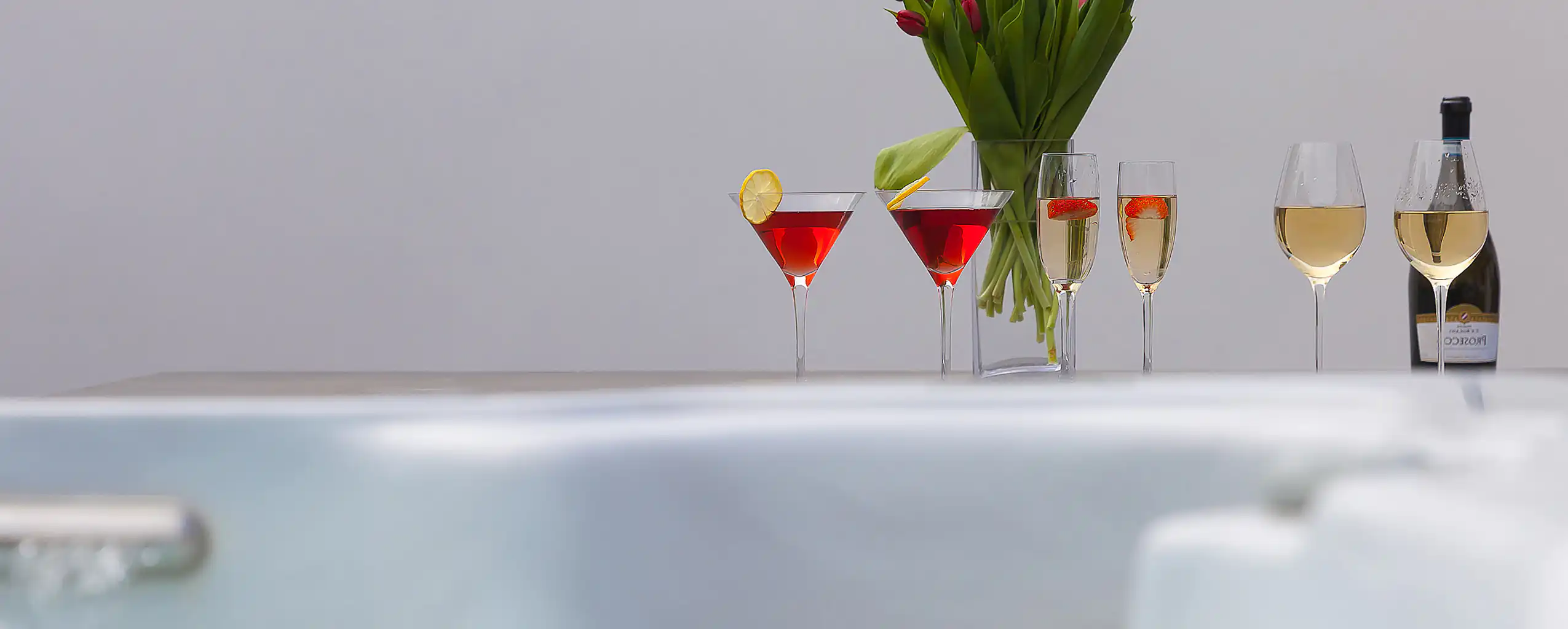 A hot tub set with a vase of flowers and a bottle of wine, perfect for a romantic evening at a Cornwall Cottage with a hot tub.