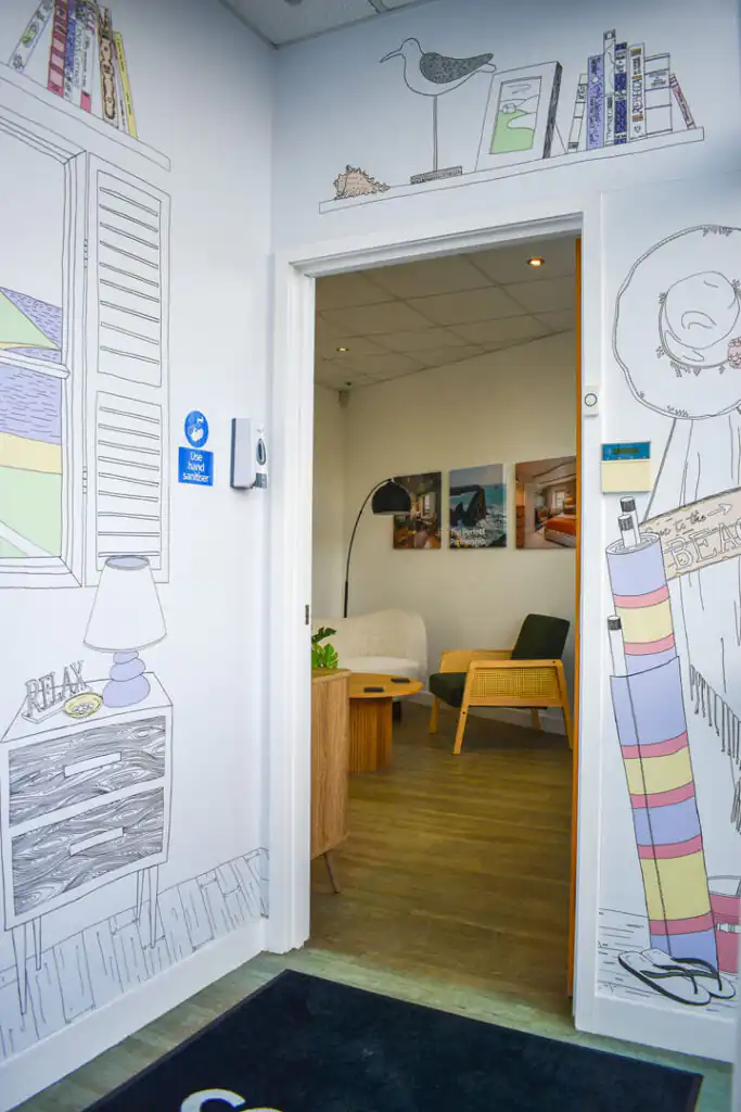 A welcoming entrance to Cornish Escapes' Carbis Bay office, featuring a door and a wall adorned with colourful drawings.