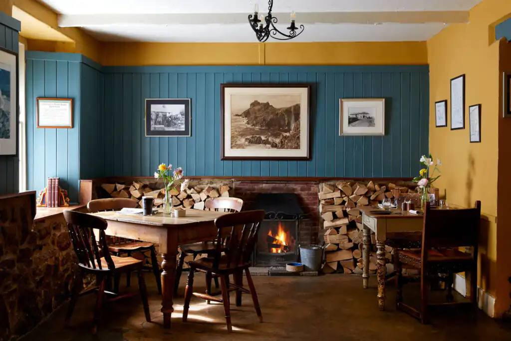 Cozy dining room featuring a fireplace and a table at the Gurnard's Head, perfect for enjoying a roast after a walk in St Ives.