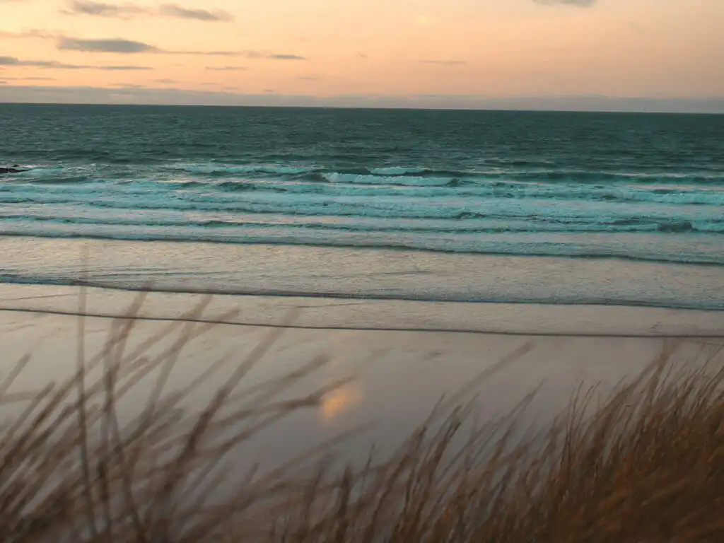 Gwithian Beach during a vibrant sunset, capturing the essence of a perfect beach day. in Hayle