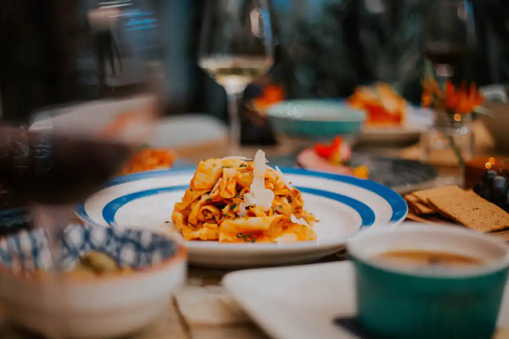 A plate of pasta paired with a glass of wine, set against a backdrop of family celebrations in Cornwall.