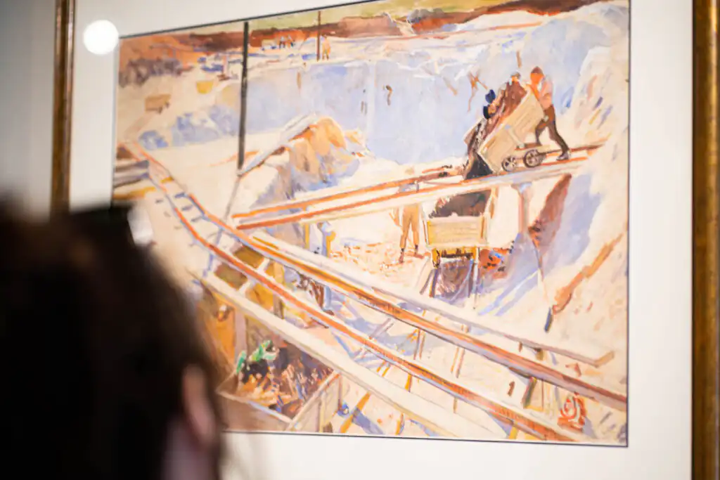 A woman admires Laura Knight's painting of a mine, a famous Cornish woman.