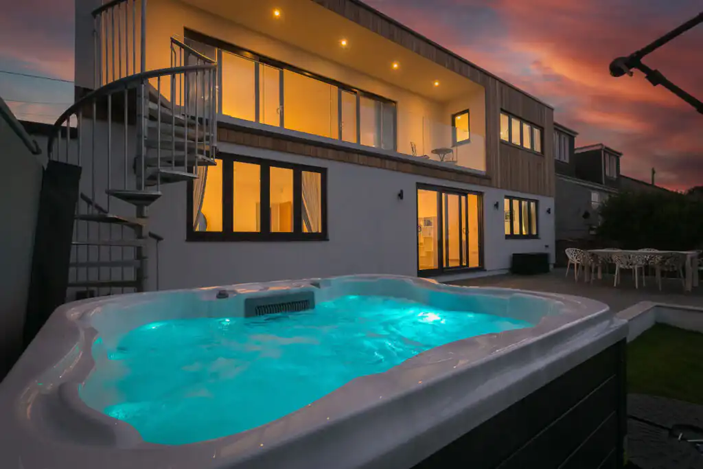 A hot tub at dusk in front of Mor Glas holiday cottage in Carbis Bay, a great way to differentiate a cottage from the market.