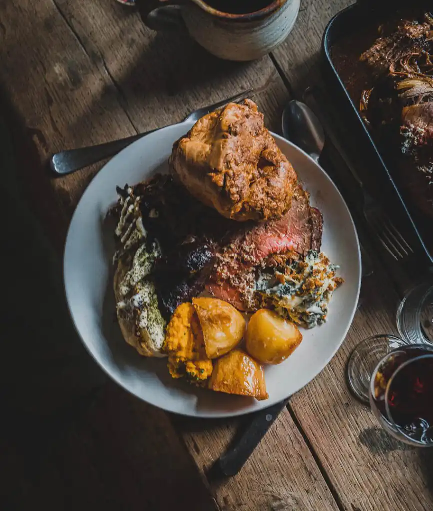 A plate featuring roast beef, seasoned potatoes, and colourful vegetables from Nancarrow Farm, a great place to eat out in Cornwall.