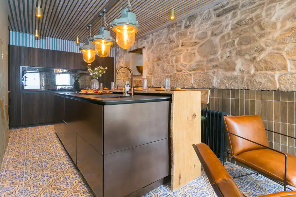 Inviting kitchen with a rustic stone wall and designer counter, highlighting the character of She Sells Sanctuary in St Ives.