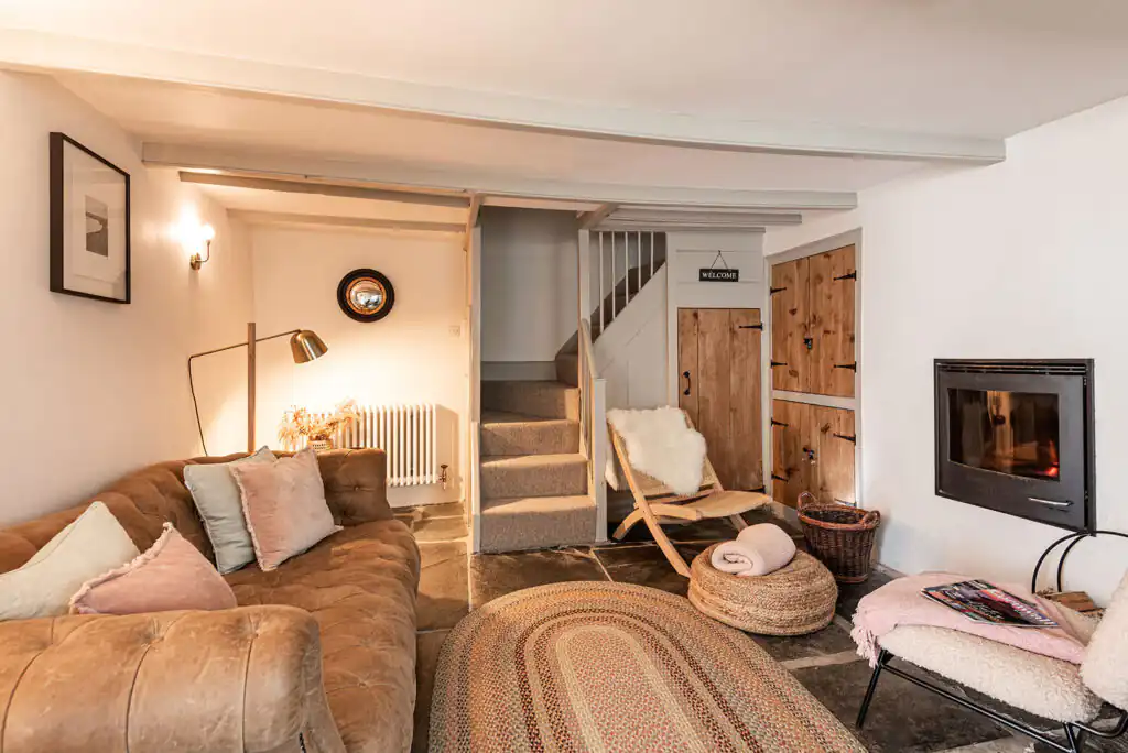 Inviting living area with a fireplace and couch, showcasing the charm of The Shambles and how to make a holiday cottage appealing to guests.