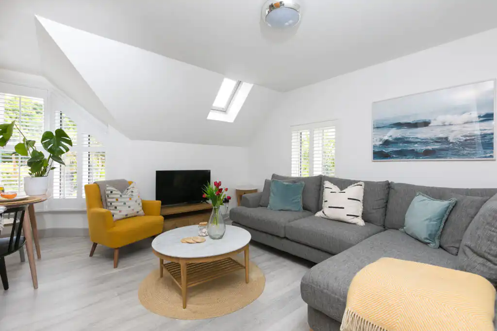 Inviting living area in Westholme, St Ives, showcasing a couch, chair, and table, ideal for relaxation during a guest's stay.