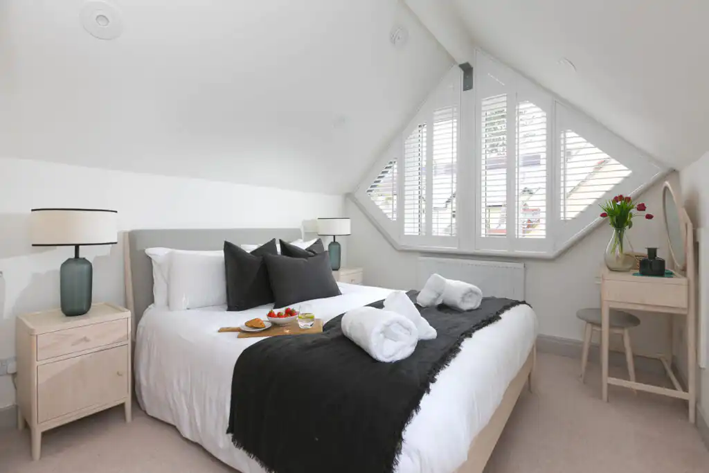 Cosy master bedroom at Westholme, featuring a bed, nightstand, and a window, perfect for a holiday retreat in St Ives.