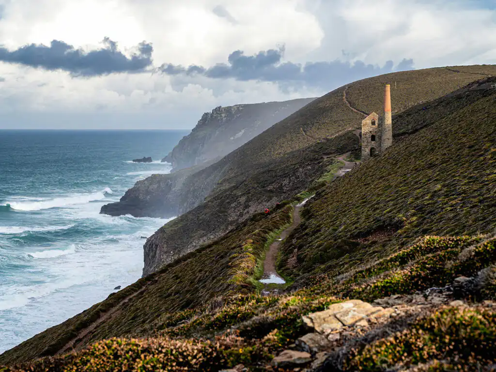 Ruined engine house near Wheal Coates, overlooking the ocean near St Agnes, with waves crashing below.