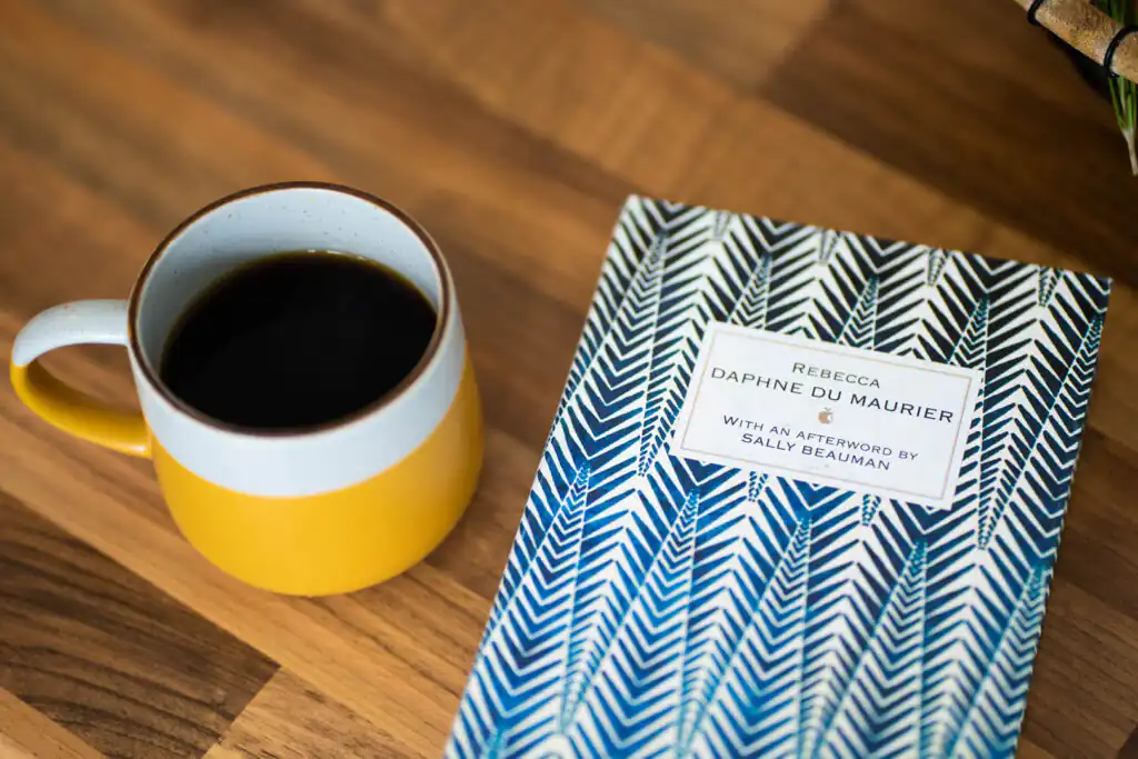 A book written by Daphne Du Maurier, an adopted famous Cornish woman, alongside an inviting cup of coffee.