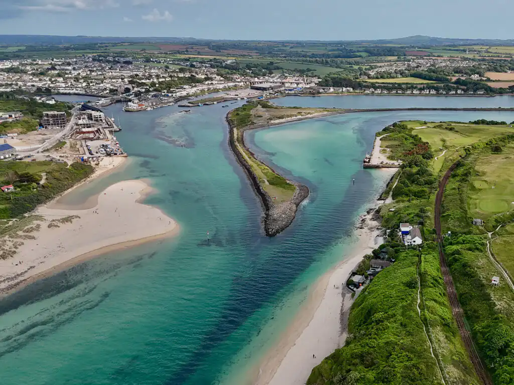 Aerial view of Hayle Estuary and Ports, showcasing it's former industrial heritage and the beach and town nestled along the coastline.