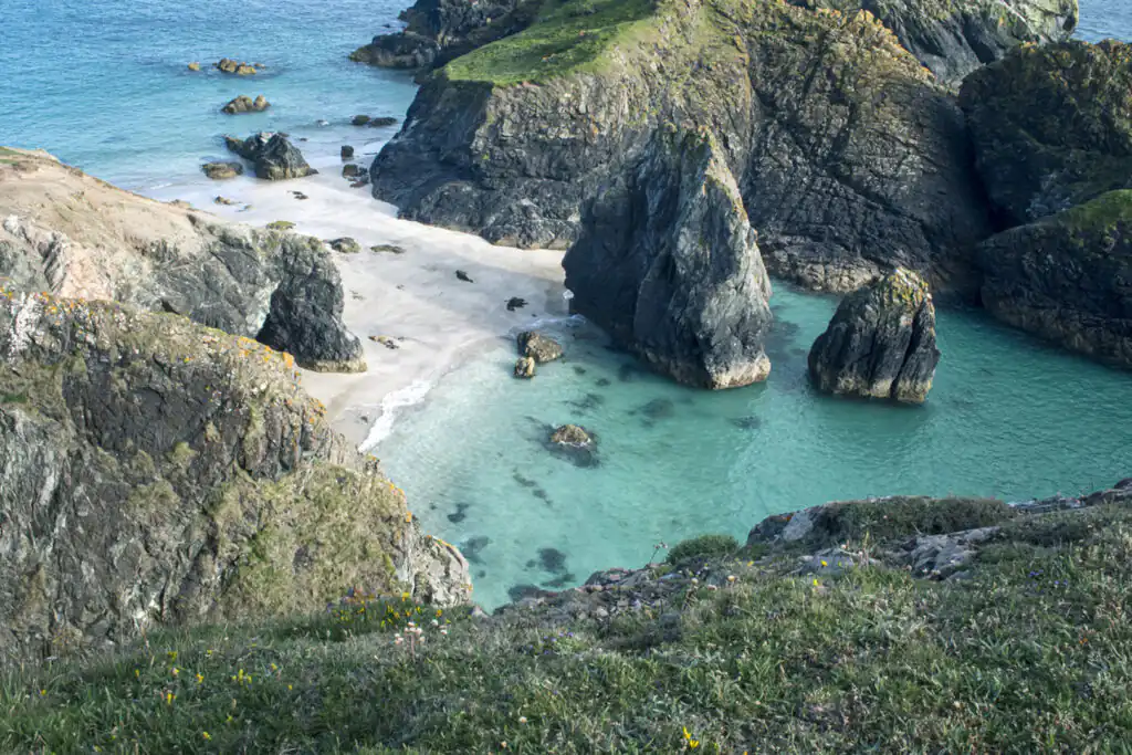 Kynance Cove features a beautiful beach with a dramatic rocky coastline, a perfect for walking route in Cornwall.