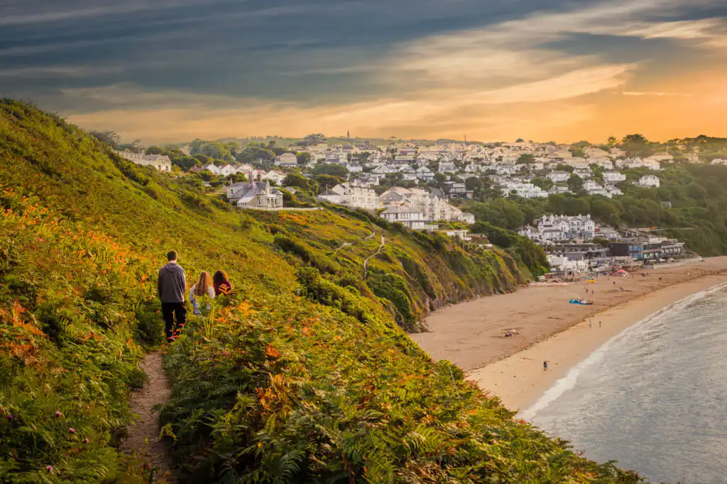 A family enjoys a leisurely walk on the Carbis Bay Coastal Path, part of the beautiful Salt Path route in Cornwall.