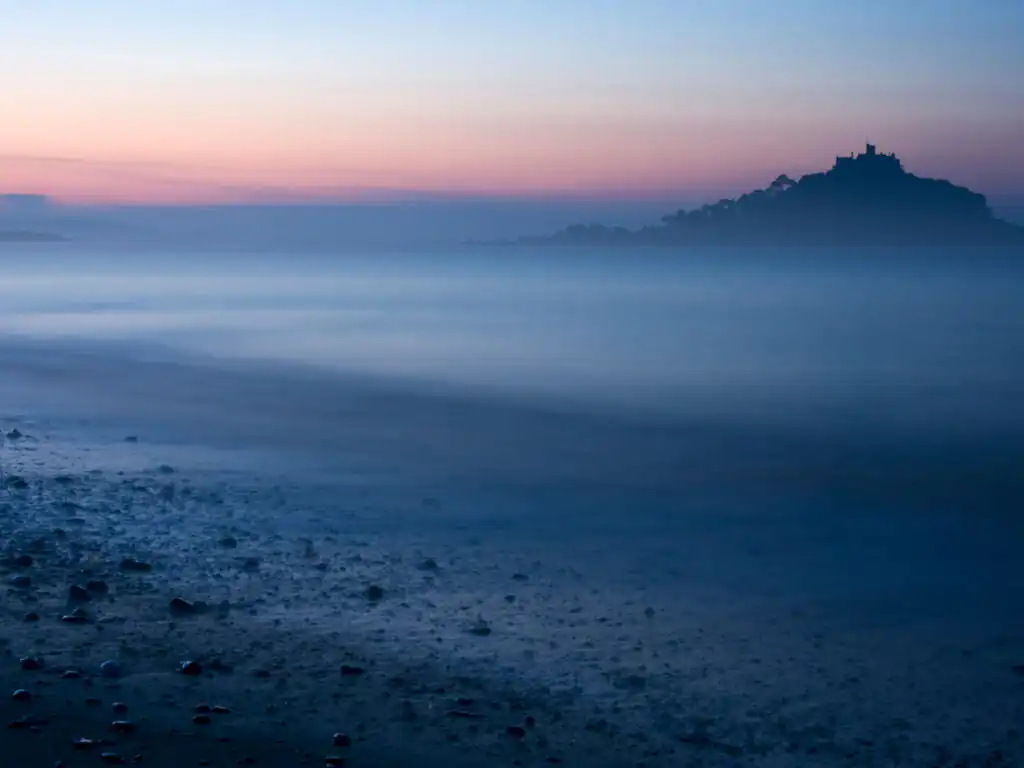 Dusk over St Michael's Mount, shrouded in mist and fog, creating a mystical atmosphere, a great thing to do in Marazion.