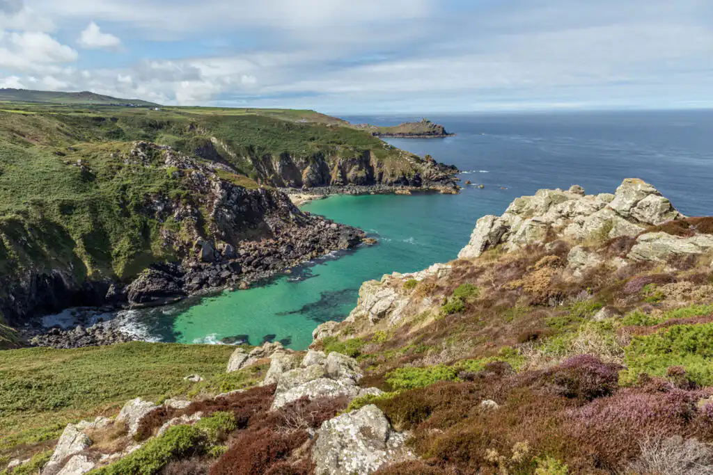 Coastal scene of Cornwall, displaying green hills and clear blue waters, perfect for exploring Zennor Cove's walking routes.
