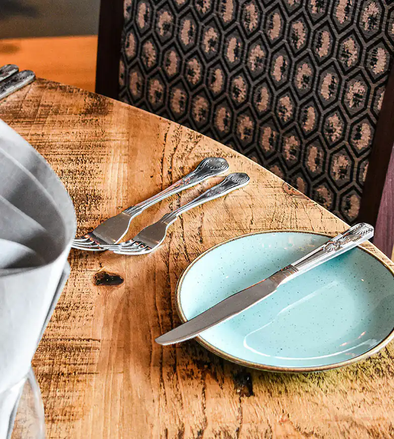 A table set with a plate and a neatly folded napkin, inviting guests to discover food and drink in Marazion.