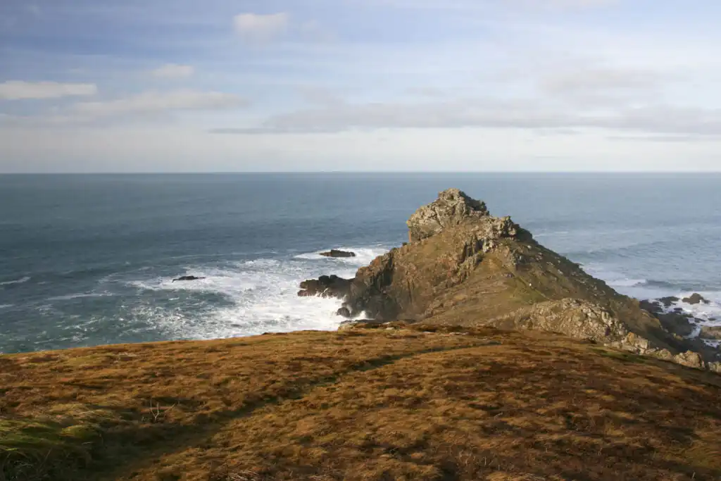 Scenic view of the ocean beside a rocky hill at Gurnard's Head, Cornwall, perfect for geological walks.
