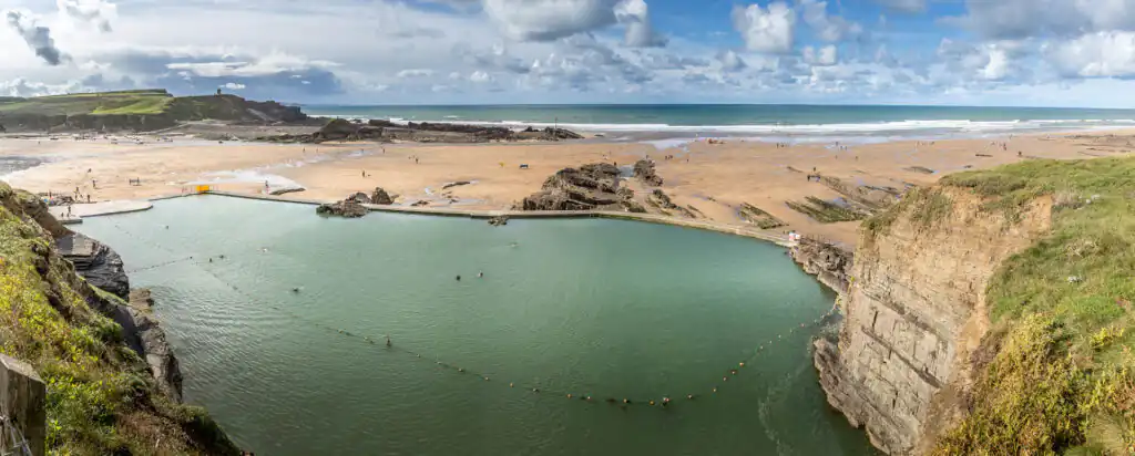 Aerial view of Bude Sea Pool and Summerleaze Beach, showcasing the beach and pool, a place for Christmas and New Year Sea Swims in Cornwall.
