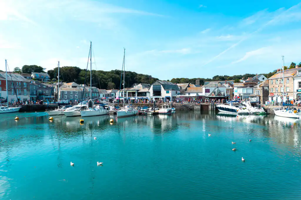 Serene view of Padstow Harbour, showcasing calm waters reflecting the sky and surrounding boats, the base for this guide on locals tips and secrets in Padstow.