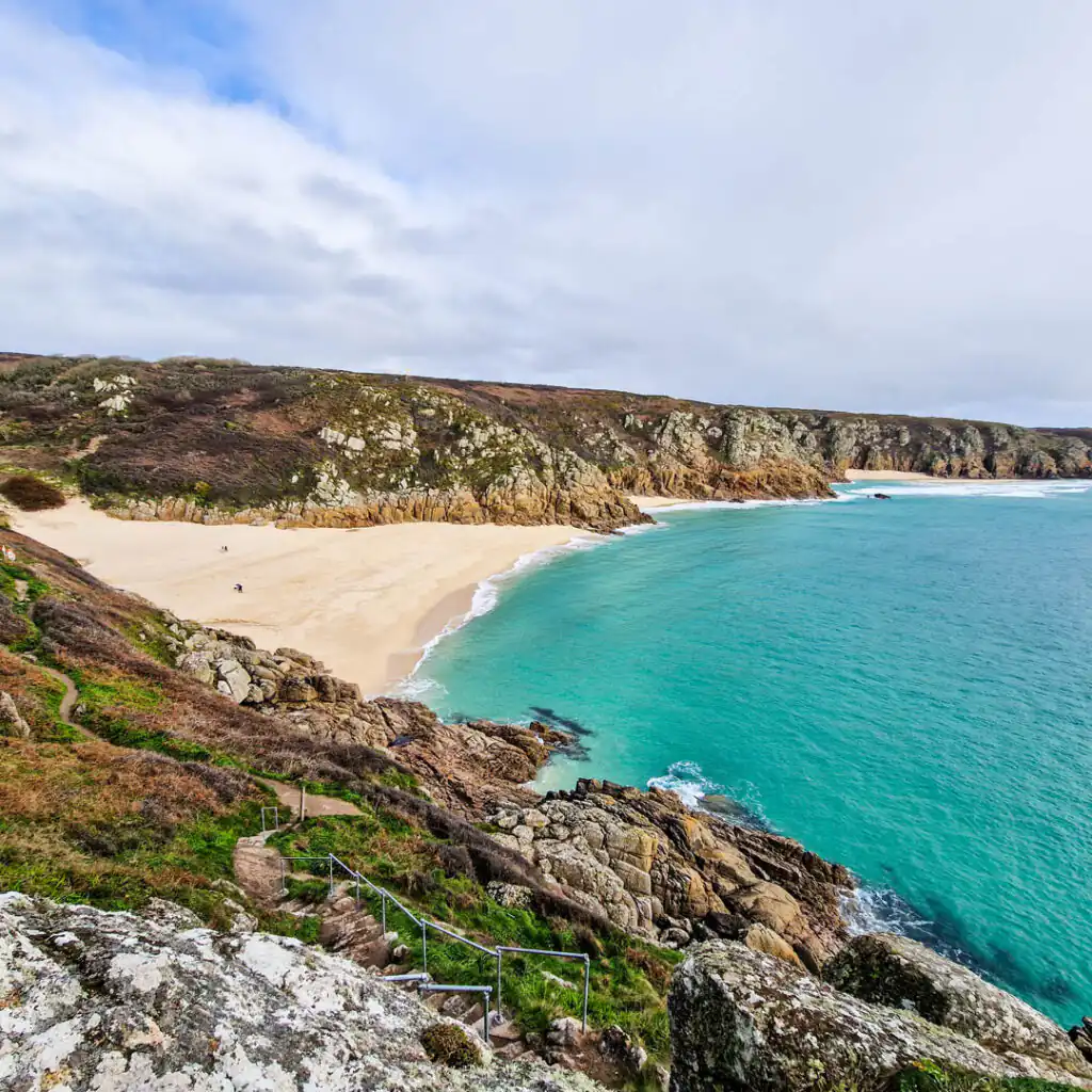 Porthcurno Beach in Cornwall, showcasing golden sand and clear blue water, perfect for celebrating a romantic Valentine's Day.