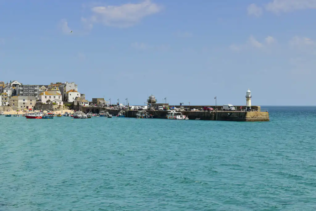 Scenic view of St Ives Harbour with boats floating on the calm water, showcasing Cornwall's beautiful coastal charm, one of the best places to stay in Cornwall.