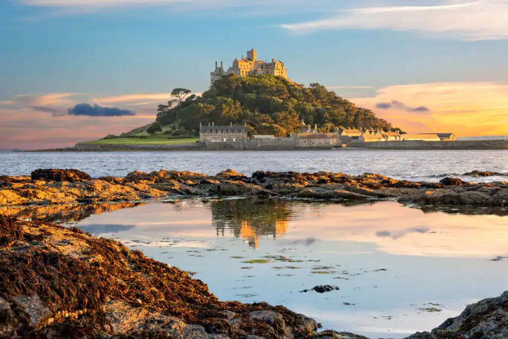 The iconic castle of St Michael's Mount in Marazion, Cornwall, rises above the sea, showcasing its historic architecture, close to the Godolphin Inn, one of the best pubs with a beer garden in Cornwall.