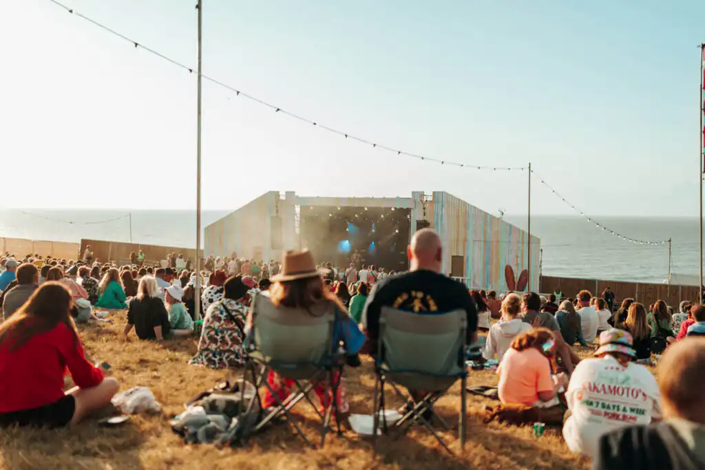 Festival-goers relax in lawn chairs, soaking up the atmosphere at the Boardmasters Festival in Newquay, a great Cornish summer festival.