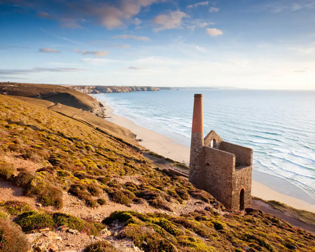 A scenic view of Towanroath Engine House on a hill, overlooking the ocean, a great thing to do in Summer in Cornwall.