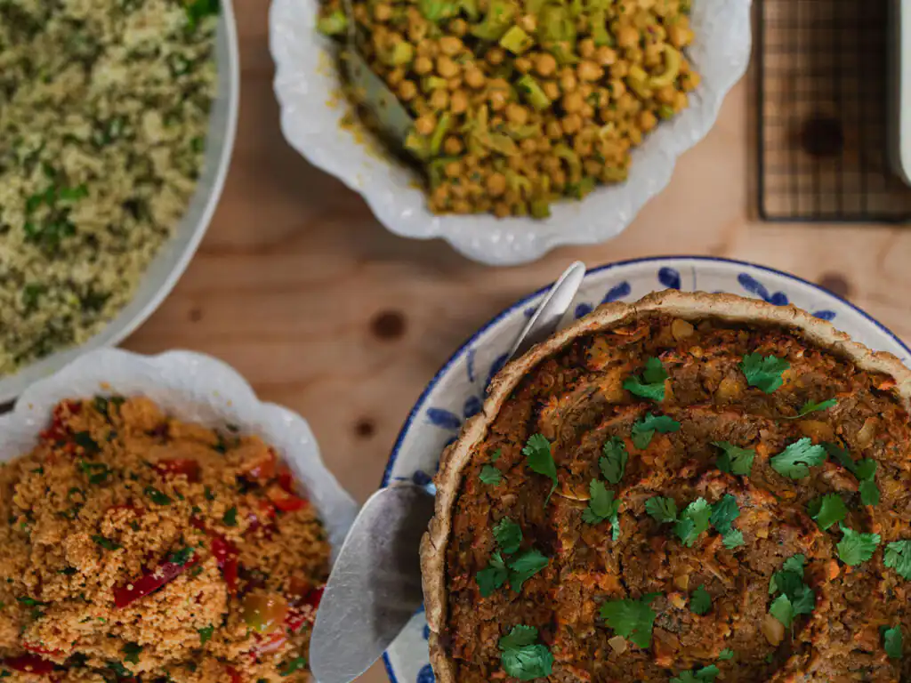 A table filled with colorful bowls of various dishes, showcasing a delightful spread from Yvette's Pantry at Carbis Bay, an unmissable place for food and drink in Carbis Bay.
