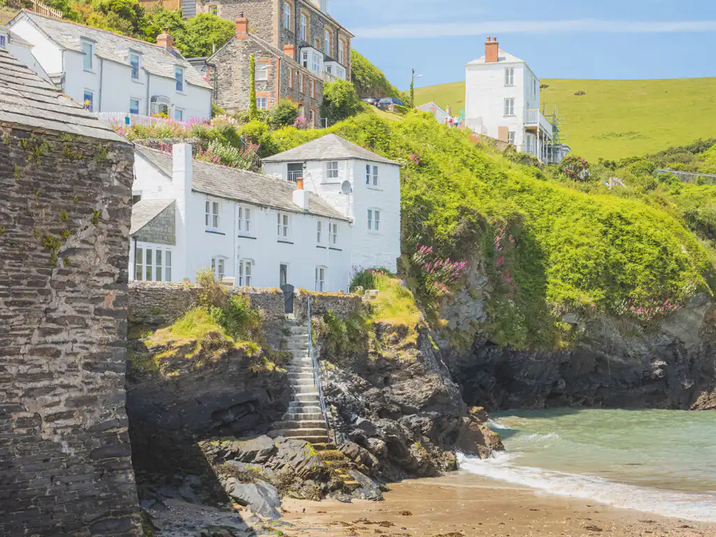 Scenic view of hillside homes overlooking Port Isaac Beach, showcasing the charming coastal architecture and landscape, a great part of Port Isaac arts and heritage.