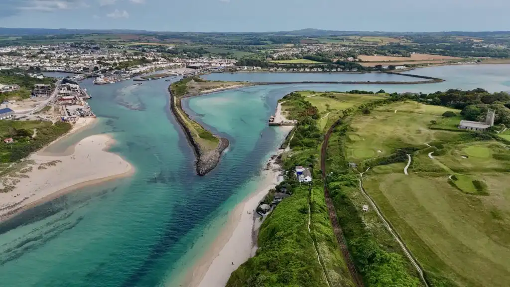 Aerial view of Hayle Estuary, showcasing sandy shores and the surrounding town landscape, a great place to walk to from Carbis Bay.