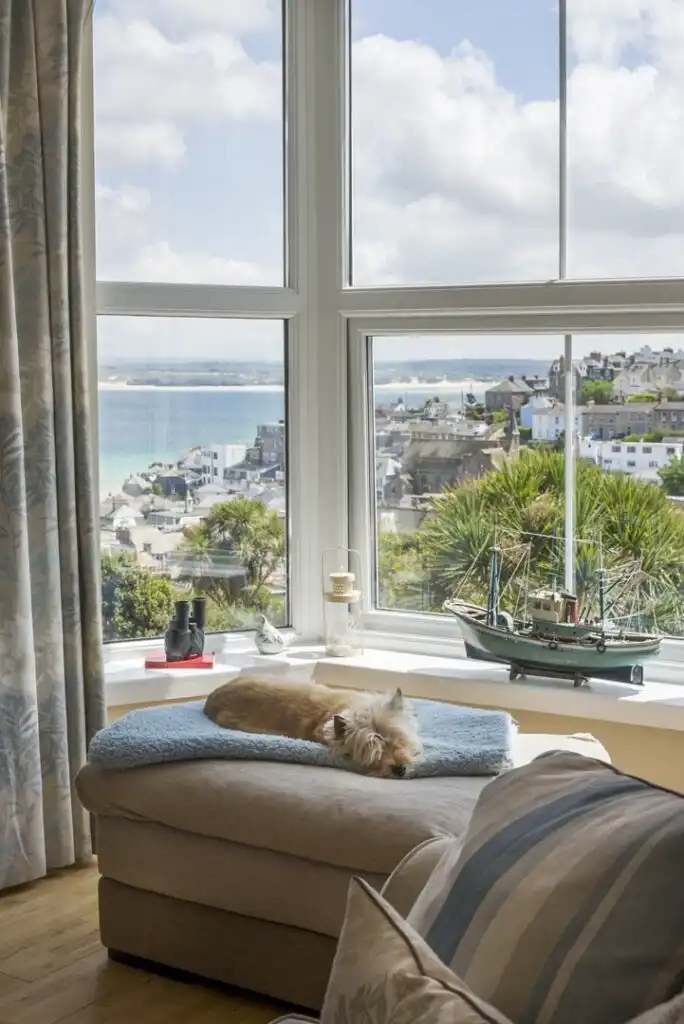 The living area at Captain's Rest with a dog sleeping, a dog friendly holiday cottage by the sea in Cornwall.