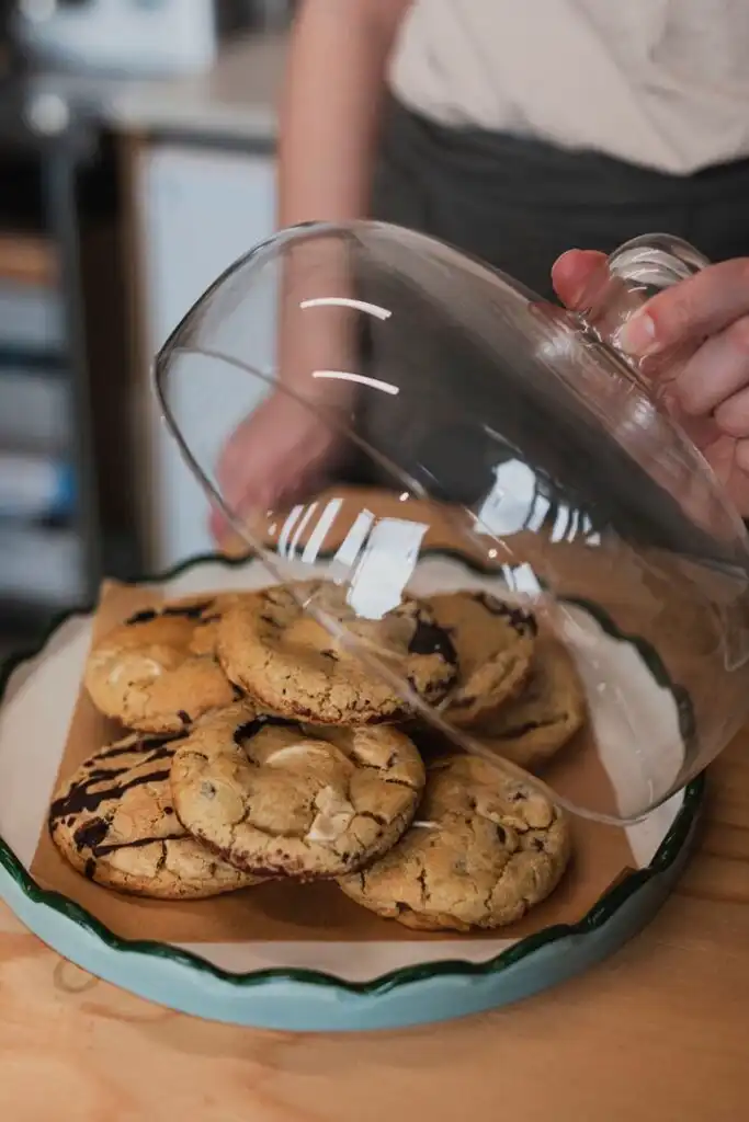 A person holds a plate of freshly baked cookies at Yvette's Pantry in Carbis Bay, showcasing a delightful treat, a great place for food and drink in Carbis Bay.